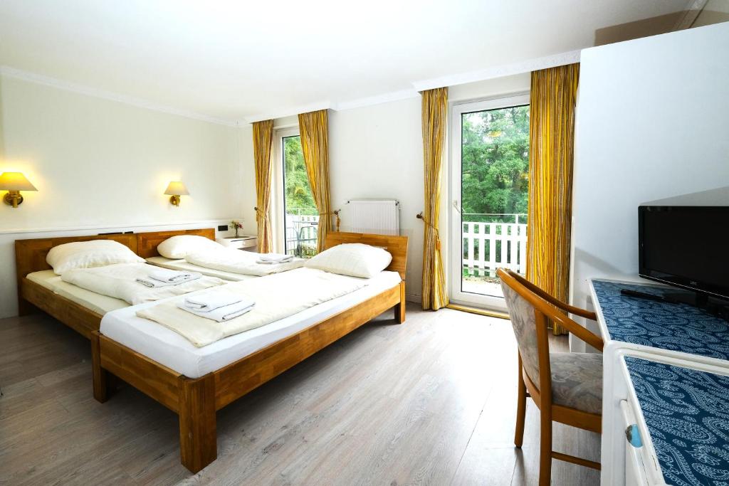 a hotel room with two beds and a television at Haus am Walde in Bad Fallingbostel