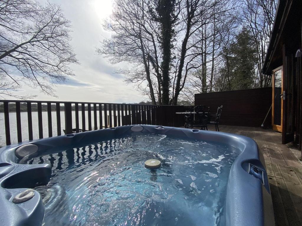 a jacuzzi tub in a yard with a fence at Chiffchaff Lodge with Hot tub in Carlisle