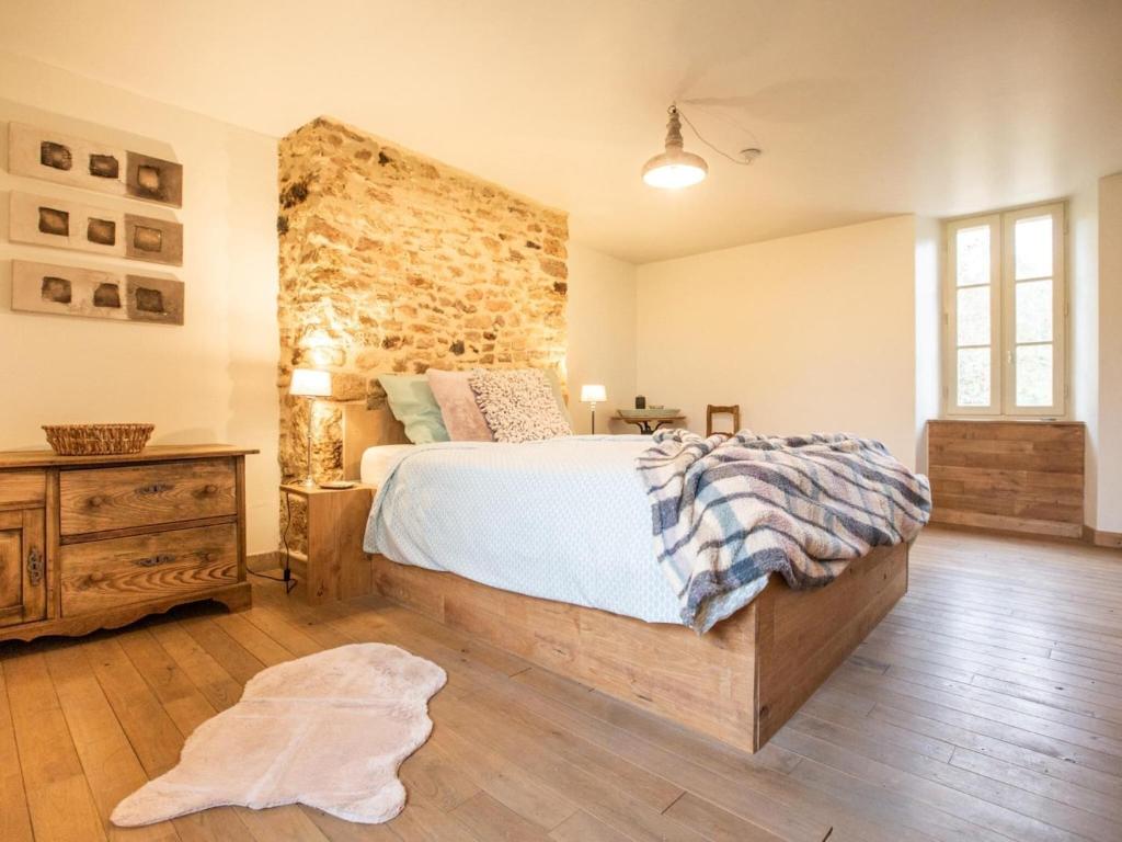 a bedroom with a large bed and a stone wall at Rustic holiday home in Loubejac with jacuzzi in Loubejac
