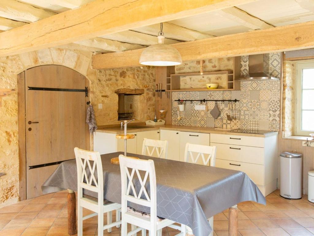 a kitchen with a table and chairs in a room at Rustic holiday home in Loubejac with jacuzzi in Loubejac