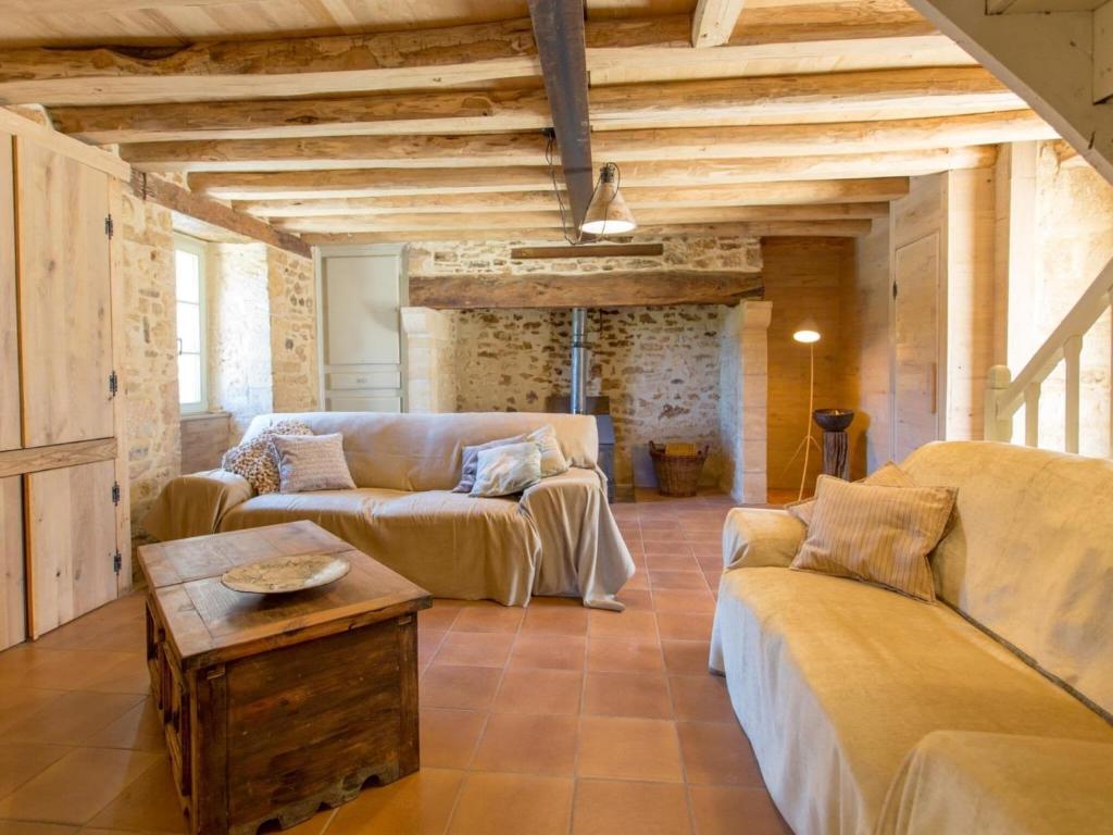 a living room with two couches and a table at Rustic holiday home in Loubejac with jacuzzi in Loubejac