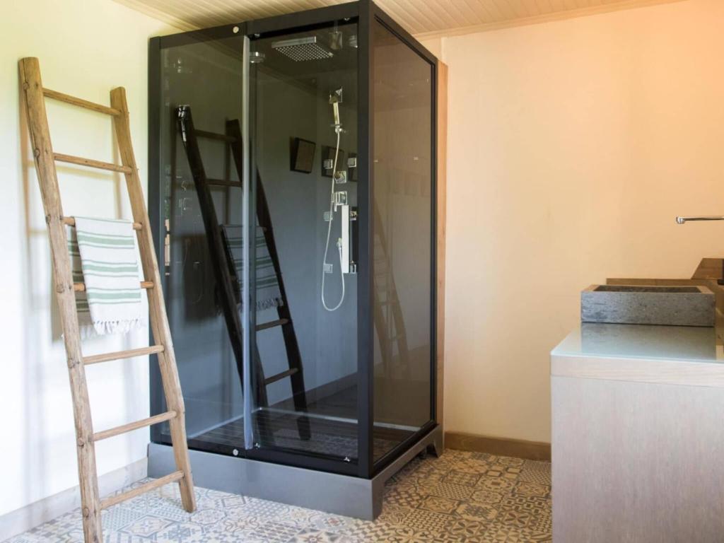 a glass shower in a room with a ladder at Rustic holiday home in Loubejac with jacuzzi in Loubejac