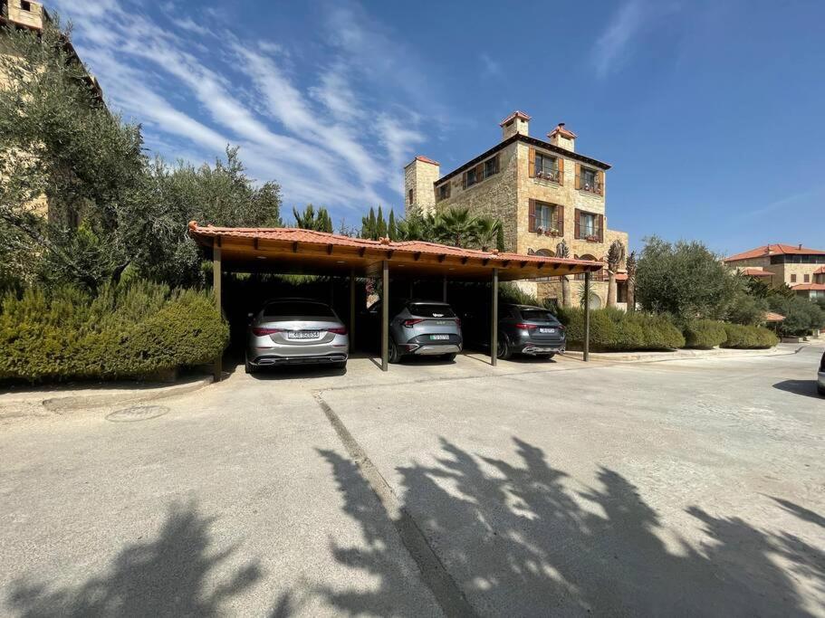 deux voitures garées dans un garage avec un bâtiment dans l'établissement Horizon Villa, à Amman