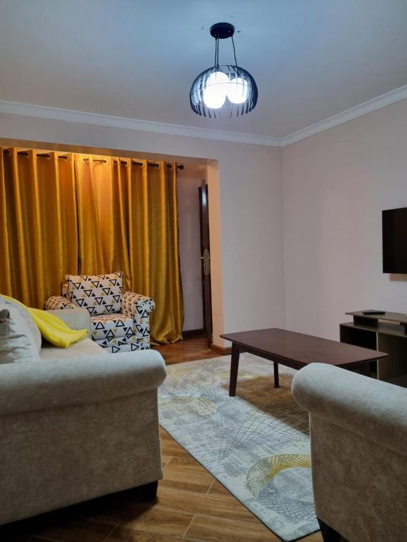uma sala de estar com um sofá e uma mesa em C & T luxury apartments em Nakuru