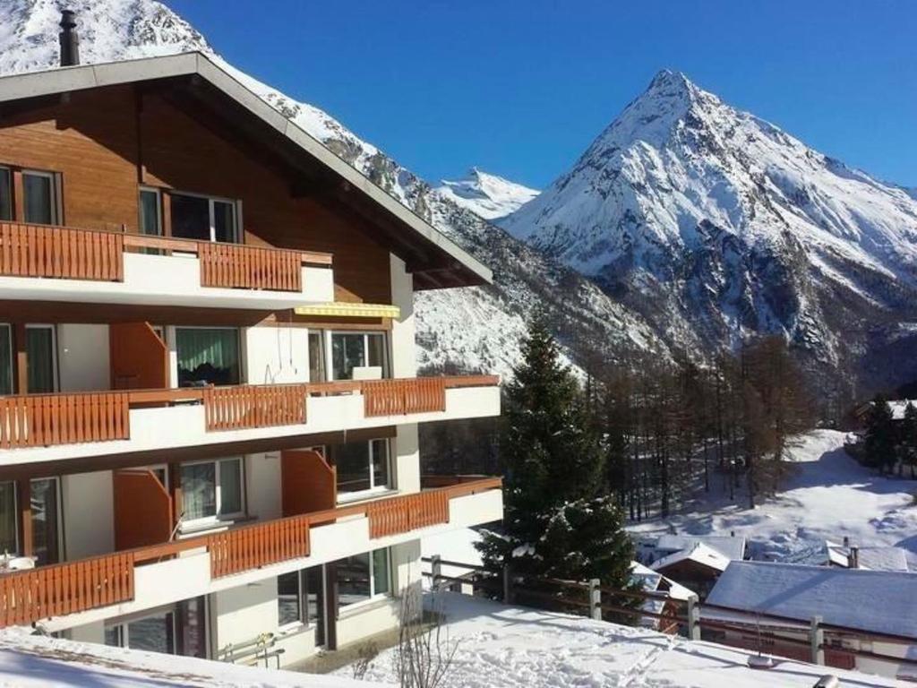 a ski lodge with a snow covered mountain in the background at Apartment Bijou by Interhome in Saas-Fee
