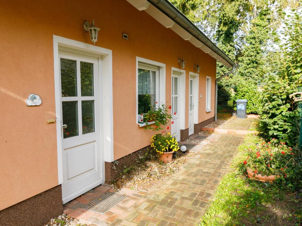 an orange house with a white door and a walkway at Holiday Home Susi by Interhome in Ostseebad Koserow