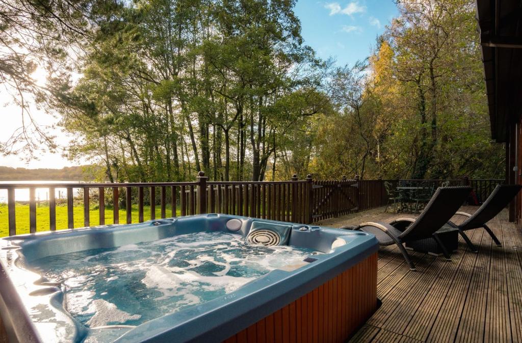 eine Whirlpool-Badewanne auf einer Terrasse in der Unterkunft Dunnock Lodge with Hot-tub in Carlisle