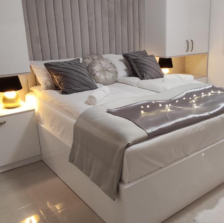 - un lit blanc éclairé dans une chambre dans l'établissement Vila Džan, à Sarajevo
