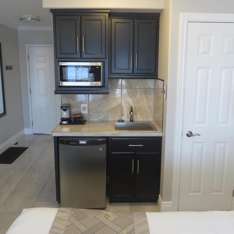 a kitchen with black cabinets and a sink at Dockside Suites in Digby