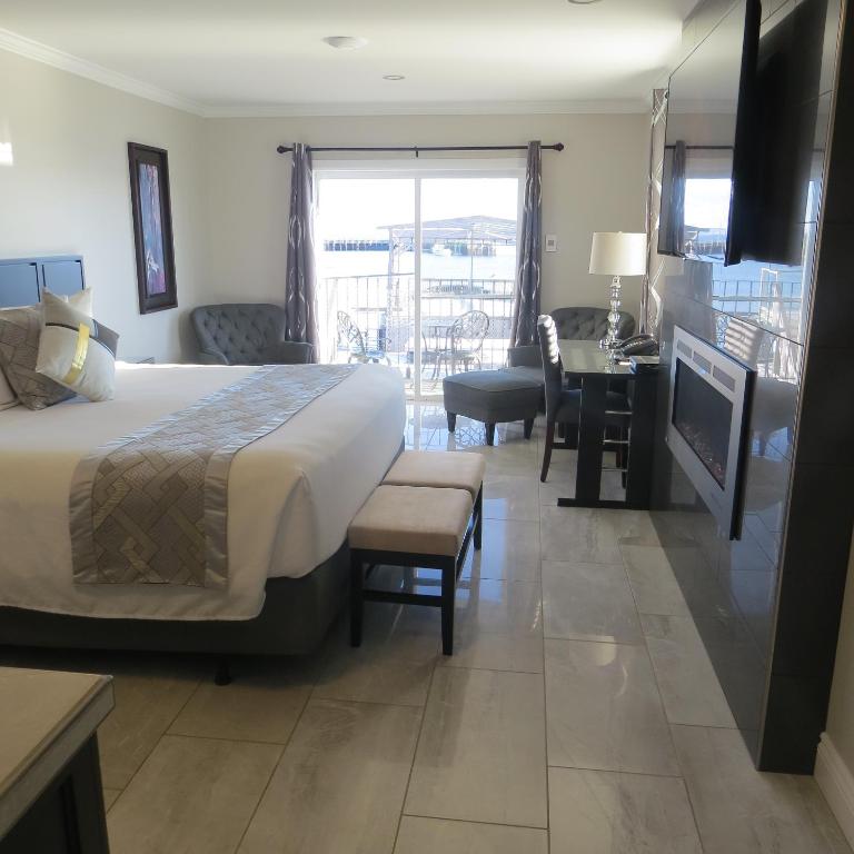 a hotel room with a bed and a desk and a balcony at Dockside Suites in Digby