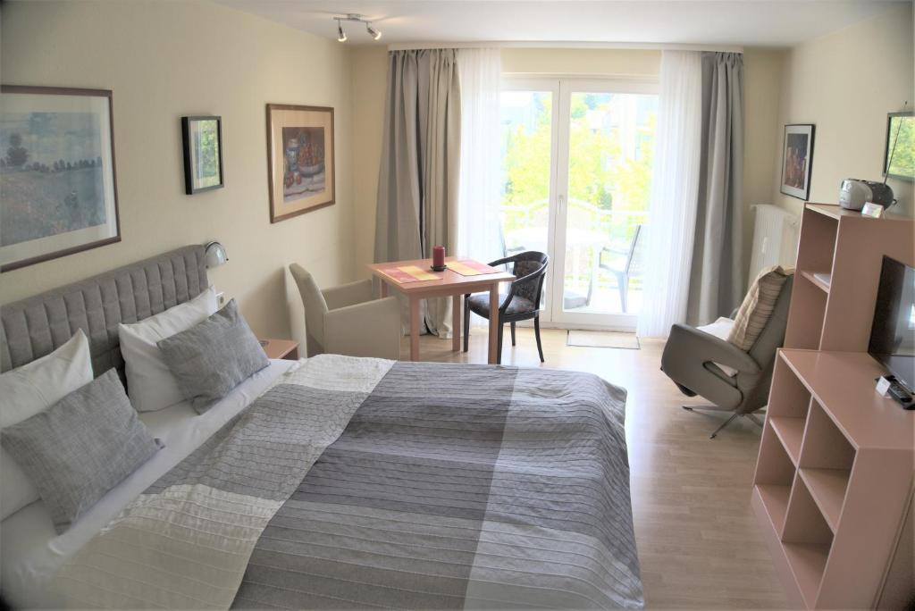 a bedroom with a large bed and a table and chairs at Modernes Appartement im Kurgebiet in Bad Kreuznach