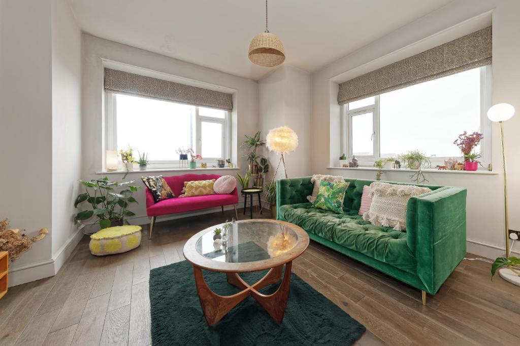 a living room with a green couch and a table at Walpole Bay Sea Views in Margate