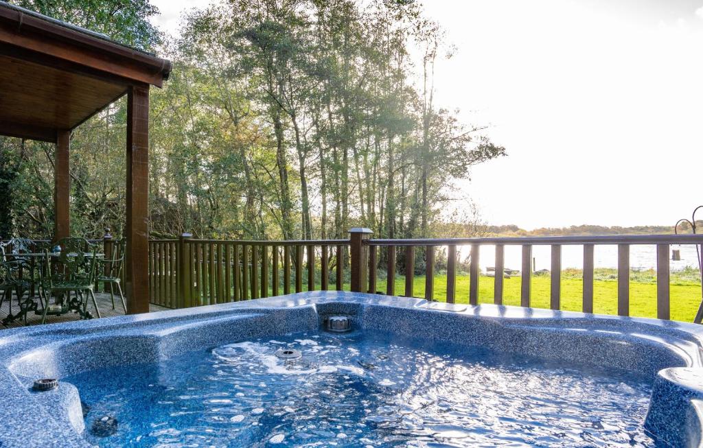 una bañera de hidromasaje en una terraza con porche en Egret Lodge with Hot-tub en Carlisle