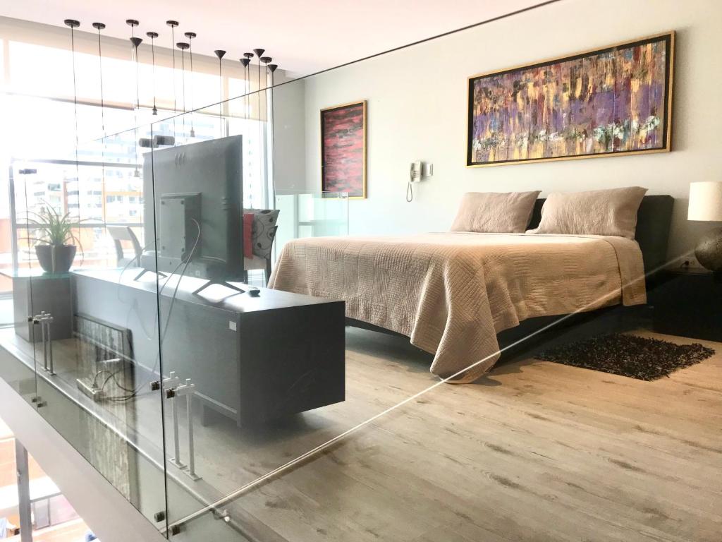um quarto com uma cama e uma televisão em Quito,lofth of Luxe en la Finlandia em Quito