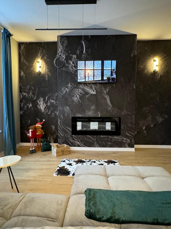 ein Wohnzimmer mit einem Sofa und einer schwarzen Wand in der Unterkunft LV Luxury Apart - One minute away from train station in Predeal