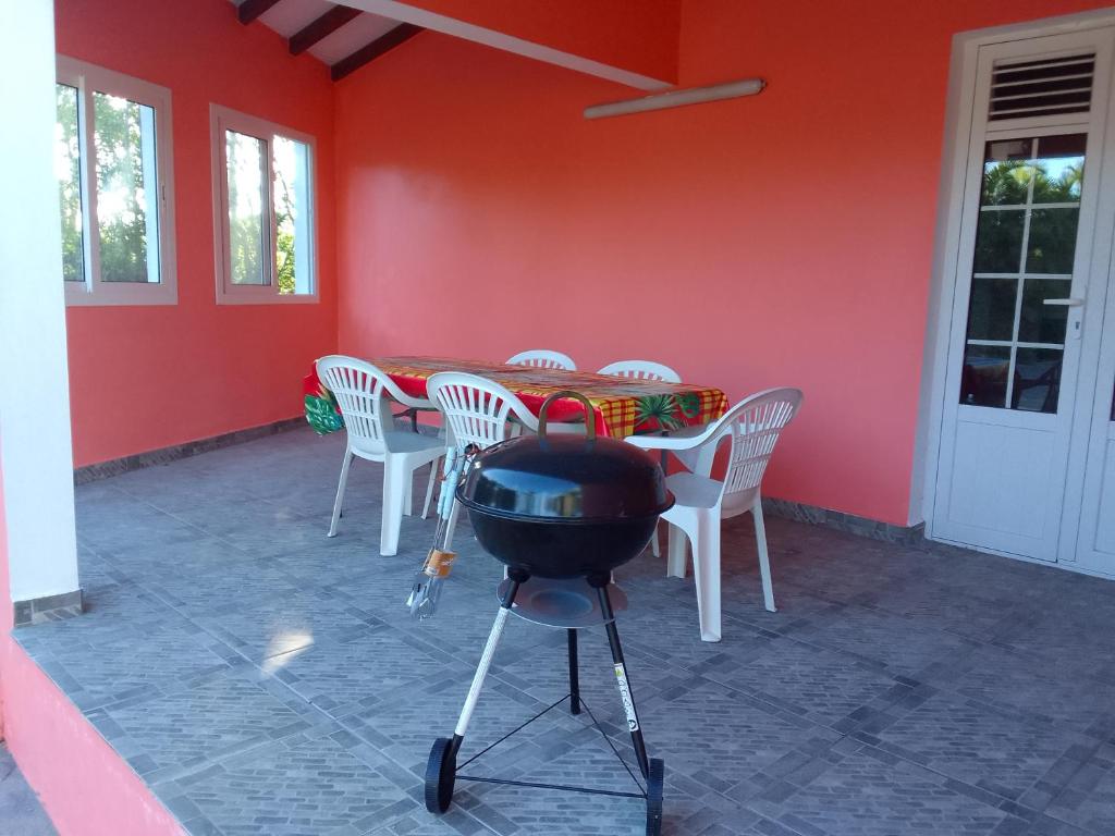 a barbecue grill in a room with a red wall at EPINAY in Sainte-Luce