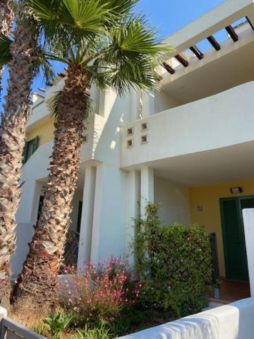 a house with two palm trees in front of it at V Appartamenti in Baia Verde