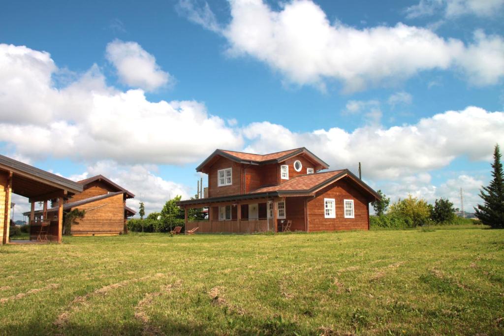 una grande casa in un campo con una casa di Evolution Camp a SantʼIppolito