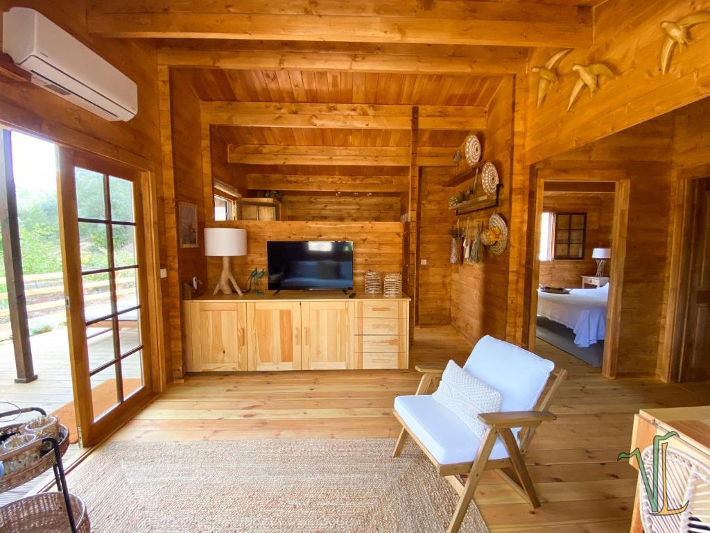 a living room of a log cabin with a television at Vale do Laranjal in Setúbal