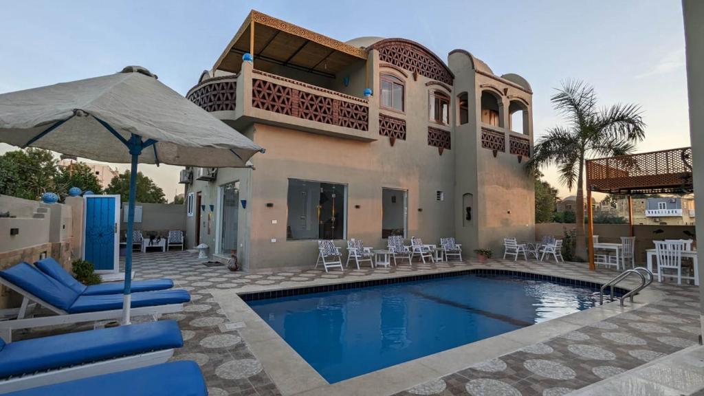 a villa with a swimming pool and a house at Yasmine Guest House in Luxor