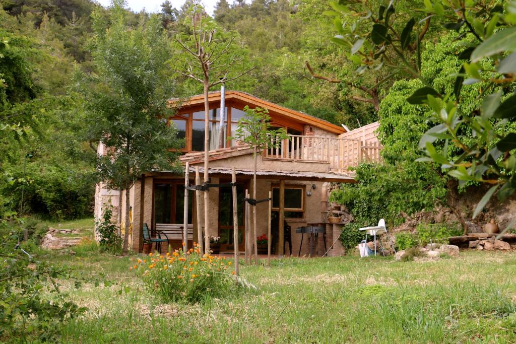una casa de madera con terraza en un campo en Casa ecológica en plena naturaleza, en Arboli
