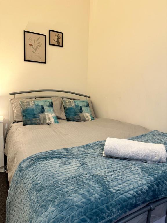 1 dormitorio con 1 cama con edredón azul en Lovely Town house Room 1, en Parkside