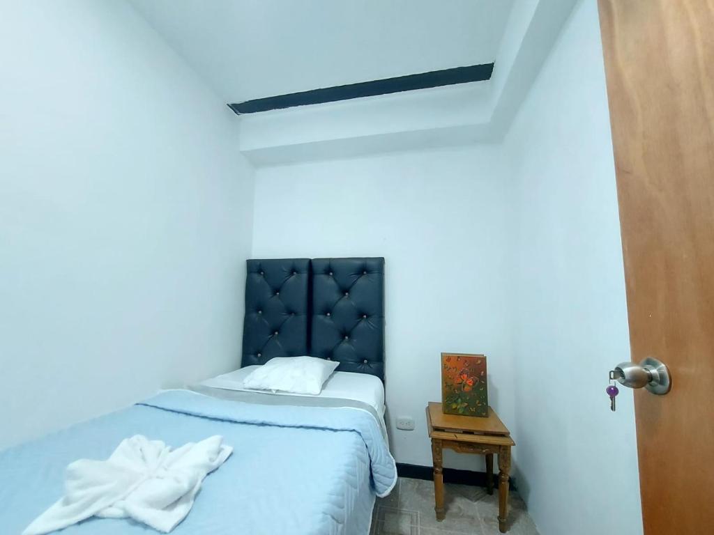 a bed in a room with a blue wall at Hostal Posada Del Corazón in Salento