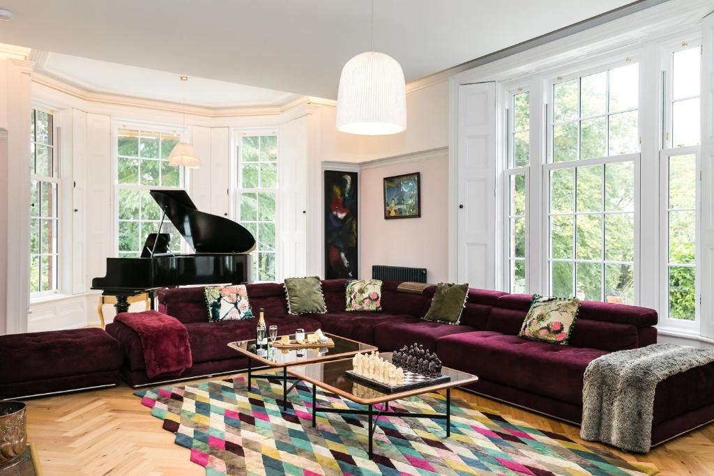 - un salon avec un canapé violet et un piano dans l'établissement The West Wing at Hillthorpe Manor by Maison Parfaite - Large 5 Bedroom House with Gardens, à East Hardwick