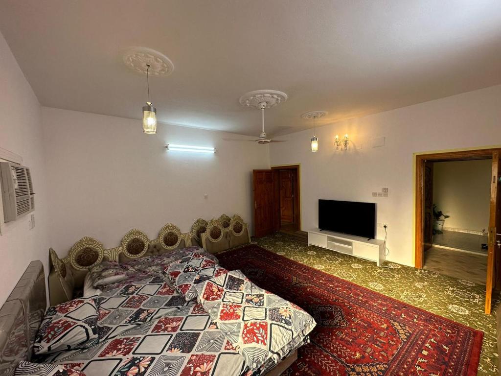 a bedroom with a bed and a flat screen tv at شقة مؤثثة , 10د بالسيارة و 20د مشياً للحرم in Al Madinah