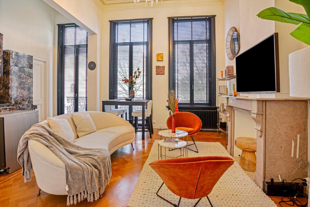 a living room with a couch and a fireplace at Museum Garden View Apartment Antwerp South in Antwerp