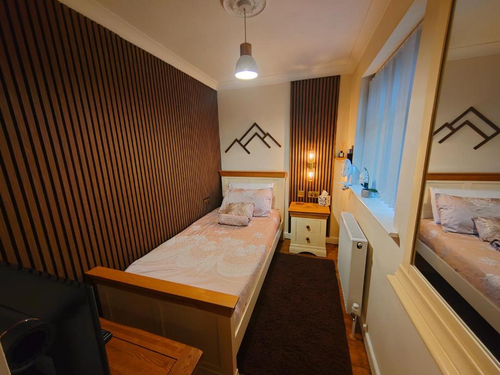 a small bedroom with two beds and a window at Castle View Guest House in Harlech