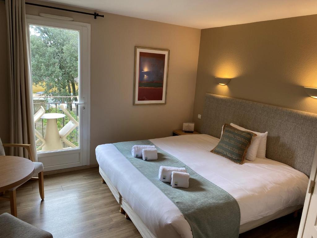 Postel nebo postele na pokoji v ubytování Logis Hôtel La Bastide De Grignan & Restaurant "La Chênaie"