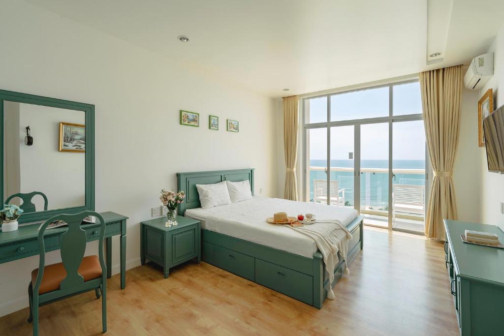 a bedroom with a bed and a desk and a window at Casa Home - Ocean Melody - Beach Front 3br Apartment in Phan Thiet