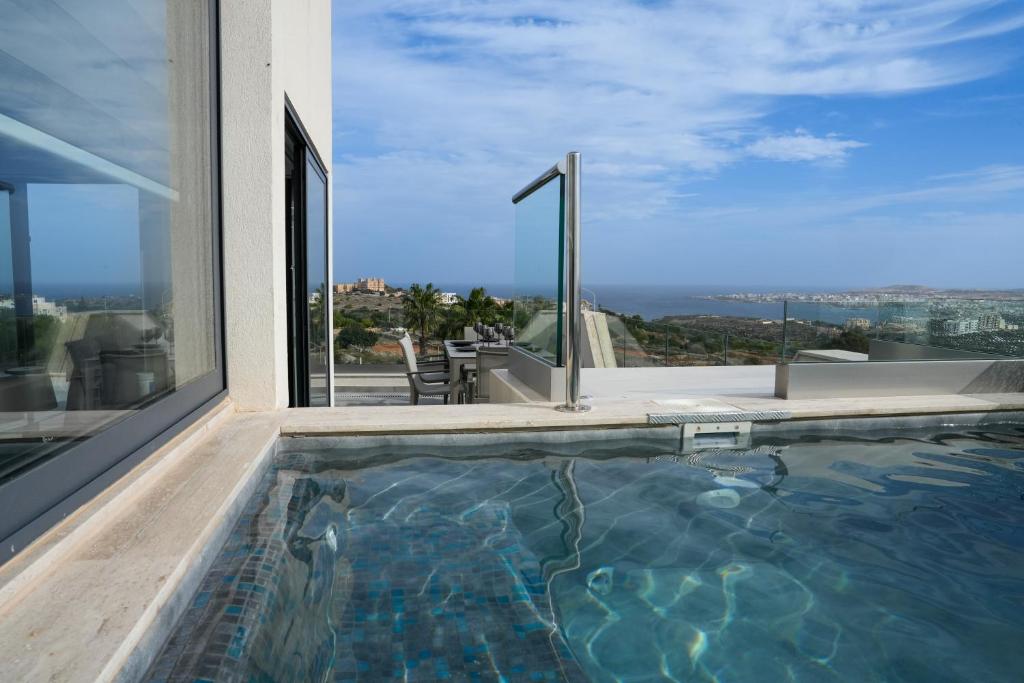 a swimming pool in a house with a view of the city at Lux Sea&Country Views with Pool in Mellieħa