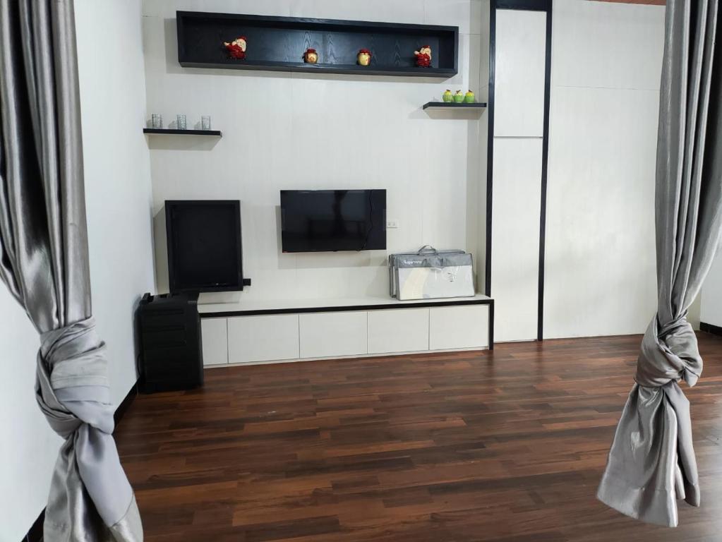 uma sala de estar com uma televisão de ecrã plano na parede em Villa Brastagi Gunung Mas em Berastagi