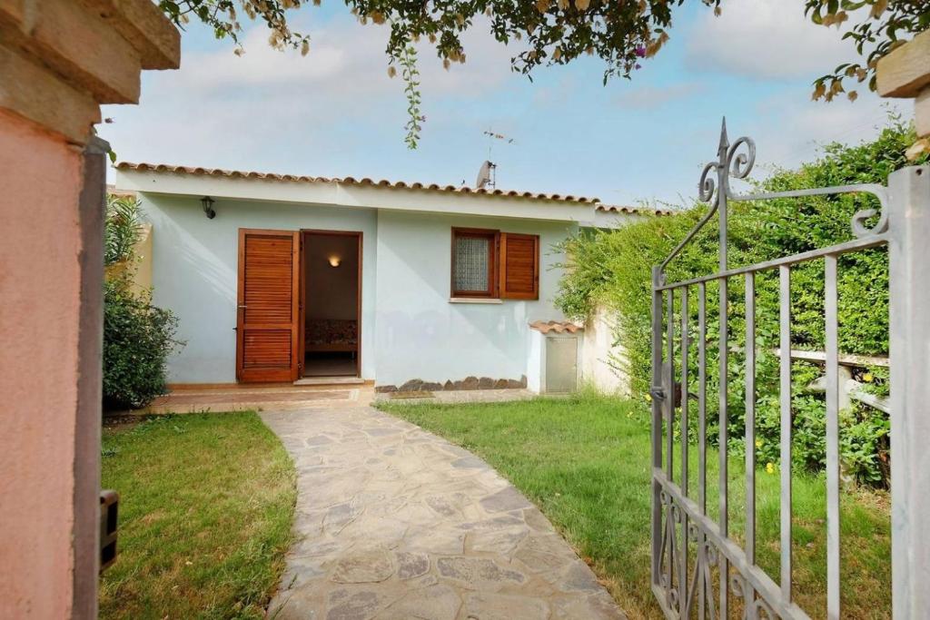 uma casa branca com um portão e um quintal em casa vacanza mika em SantʼAnna Arresi
