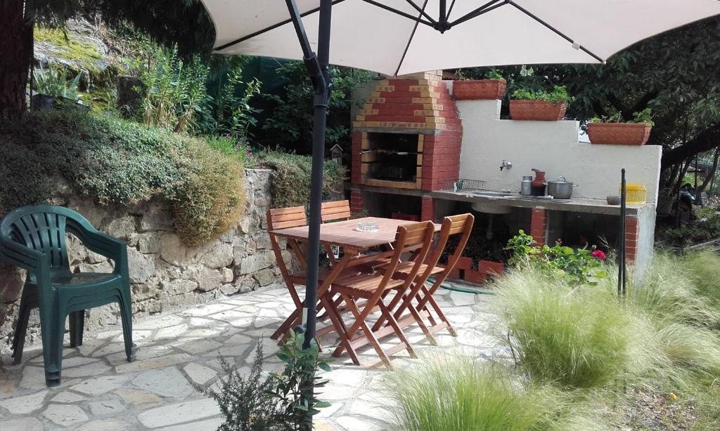 a table and chairs under an umbrella in a garden at Dortoir Bulgarana - Bourg Argental in Bourg-Argental