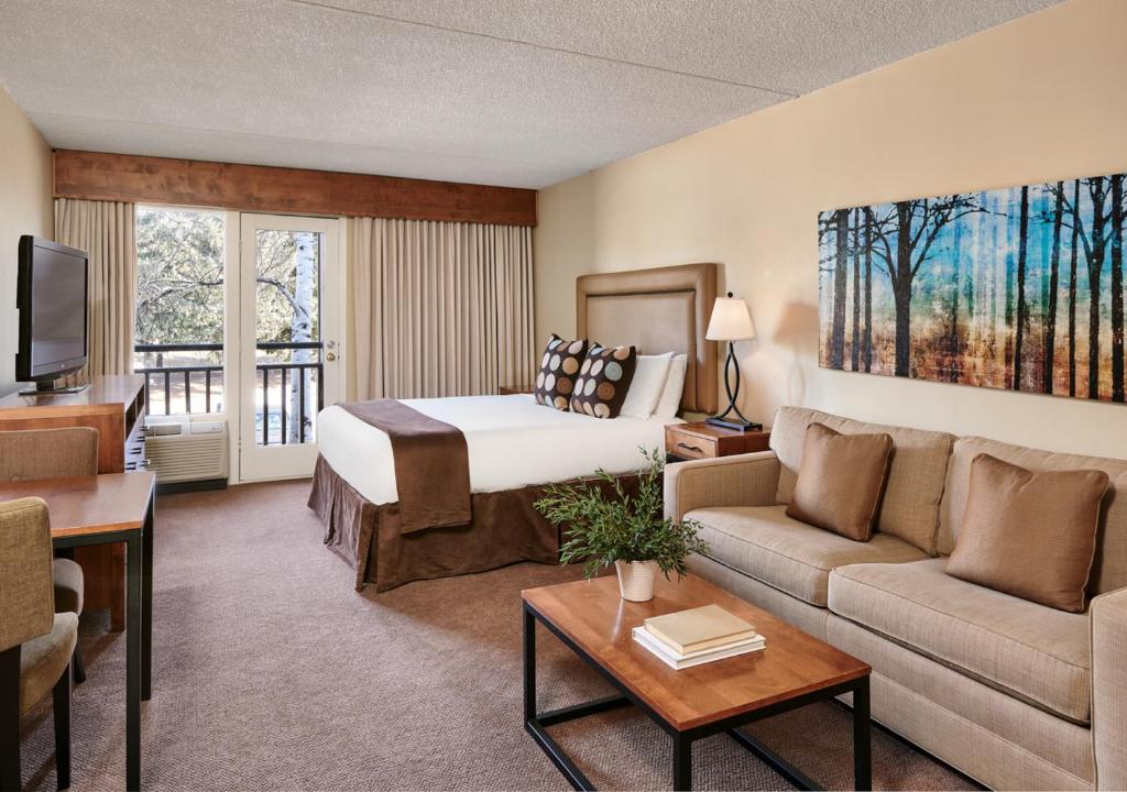 a hotel room with a bed and a couch at The Inn at Aspen in Aspen