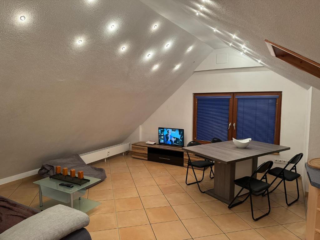 een woonkamer met een tafel en een televisie bij DG Wohnung in Schwenningen in Villingen-Schwenningen