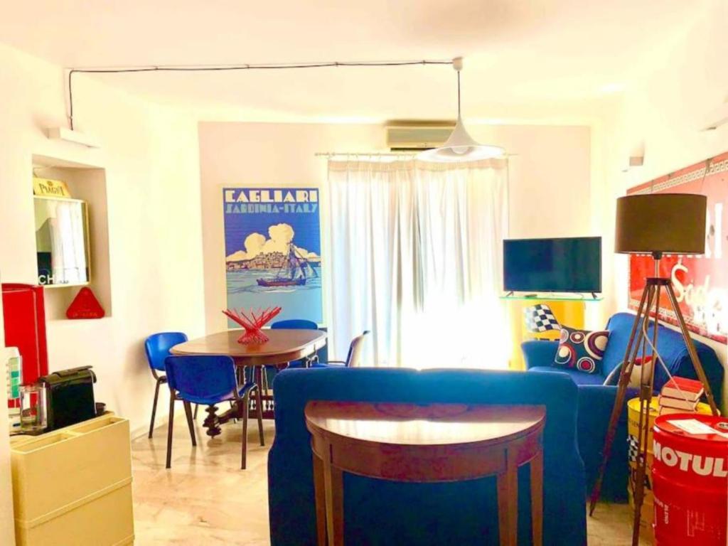 sala de estar con sofá azul y mesa en Appartamento Cagliari centro con vista sul porto, en Cagliari