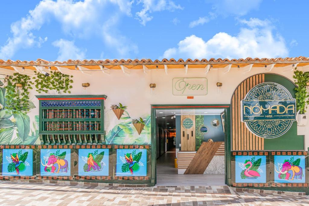 a store front with paintings of flamingos on it at NOMADA HOTEL GUATAPE in Guatapé