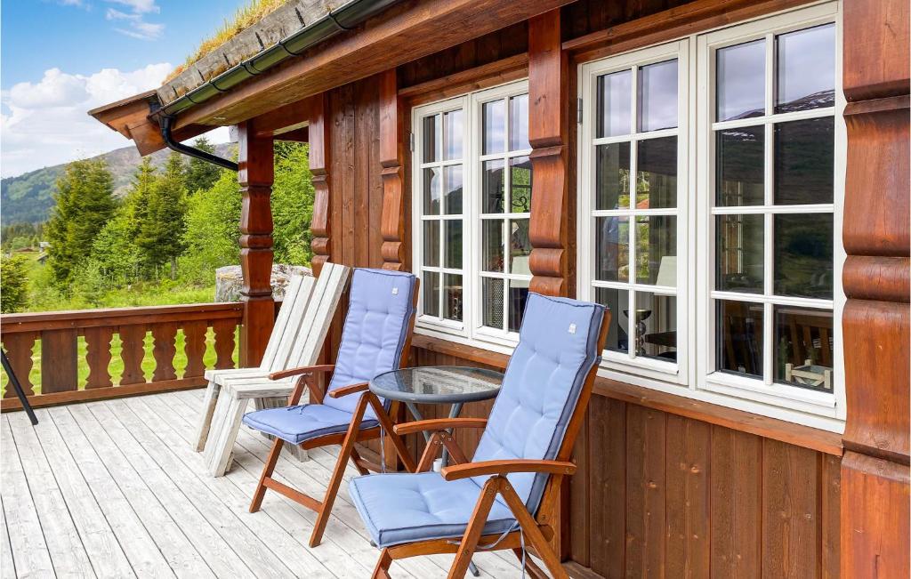 2 sillas y una mesa en el porche de una cabaña en 4 Bedroom Awesome Home In Nordfjordeid, en Nordfjordeid