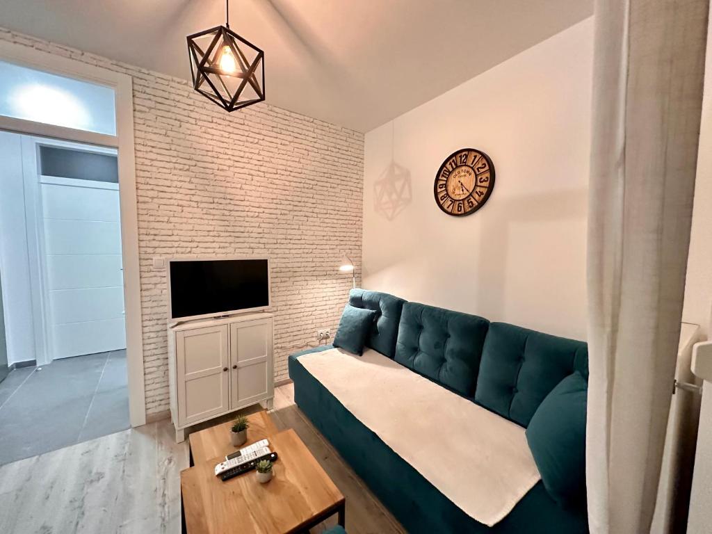 un soggiorno con divano blu e TV di Lux Apartment III Prijedor a Prijedor