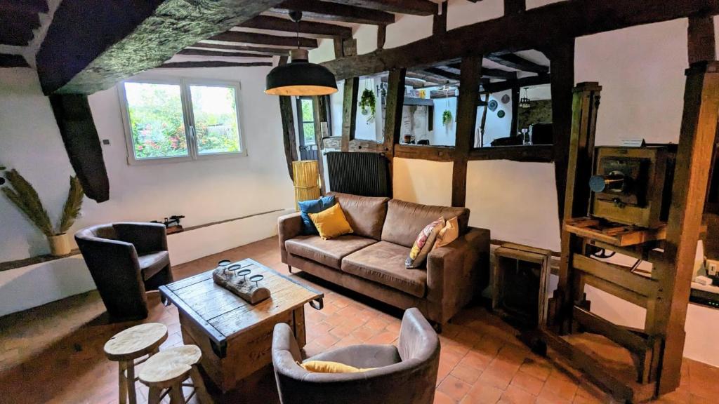 ein Wohnzimmer mit einem Sofa und einem Tisch in der Unterkunft La Dent de Croiacus - Gîte 4 personnes proche de Chambord in Chambord