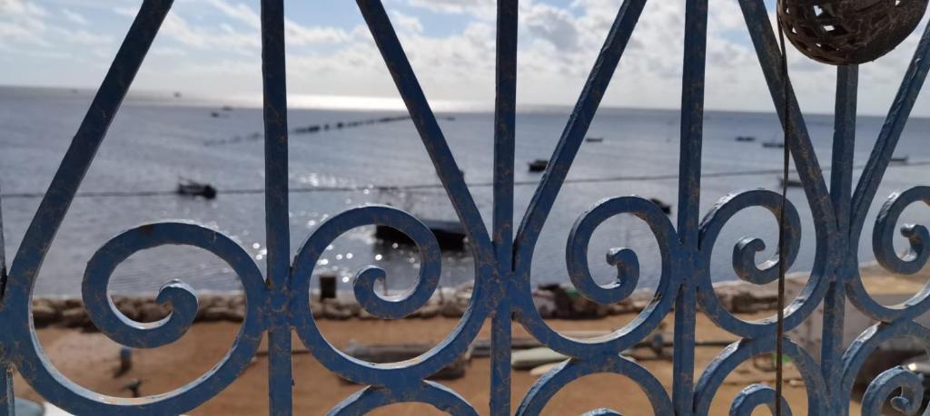 a view of the beach through a gate at Beit El Ezz - la petite in Ouled Yaneg