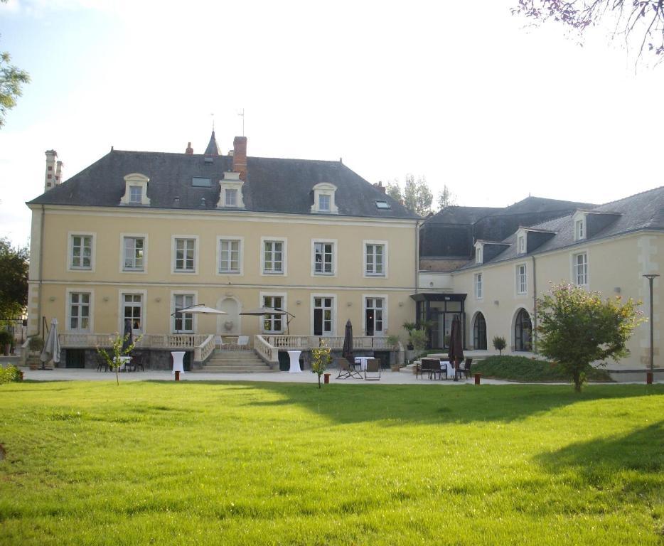 a large white house with a lawn in front of it at Hôtel Le Saint Martin in Sablé-sur-Sarthe