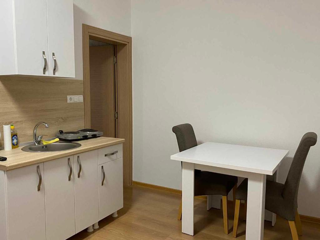 a kitchen with a sink and a table and chairs at Apartmani Bella in Krževići