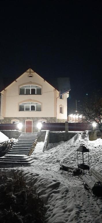 a building in the snow at night with lights at Barda in Vorokhta