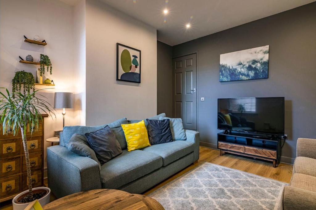 een woonkamer met een bank en een flatscreen-tv bij 3 BR Terraced House in Beeston with Easy City Centre Access in Nottingham