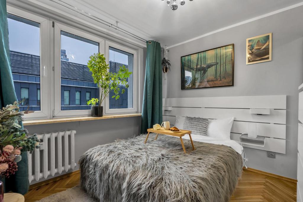 um quarto com uma cama grande e uma mesa. em Central 2-Bedroom Apartment - Balcony, City View, Top Location - by Rentujemy em Varsóvia